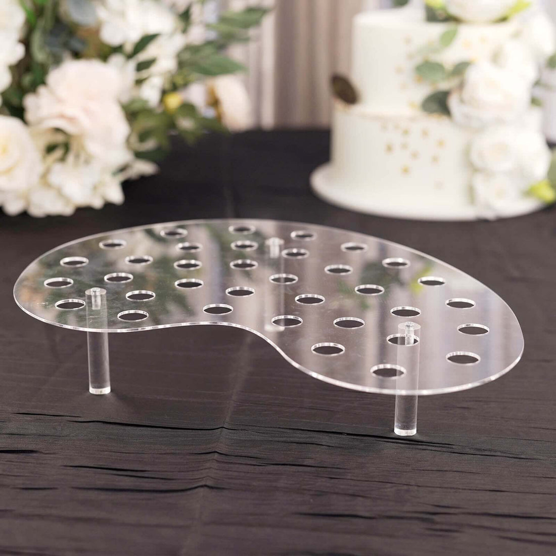 Acrylic cake display stand with holes and clear legs, ideal for showcasing desserts.