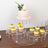 Clear acrylic cupcake stand with cupcakes and a cake, elegantly decorated with flowers.