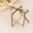 Clear gift box with gold ribbon bow on a soft floral background