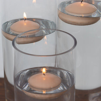 Floating candles in clear glass vases with water.