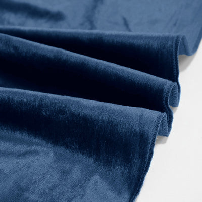 Close-up of navy blue velvet fabric folds with soft texture
