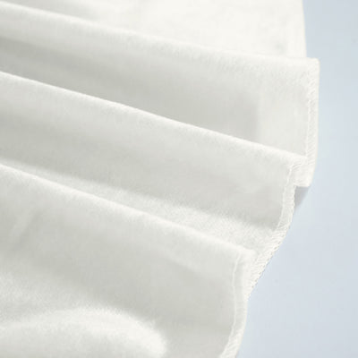 Close-up of white pleated fabric with stitched edges and soft texture