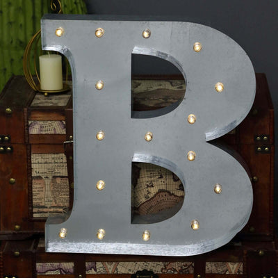 Large illuminated letter B with marquee lights on a decorative box background