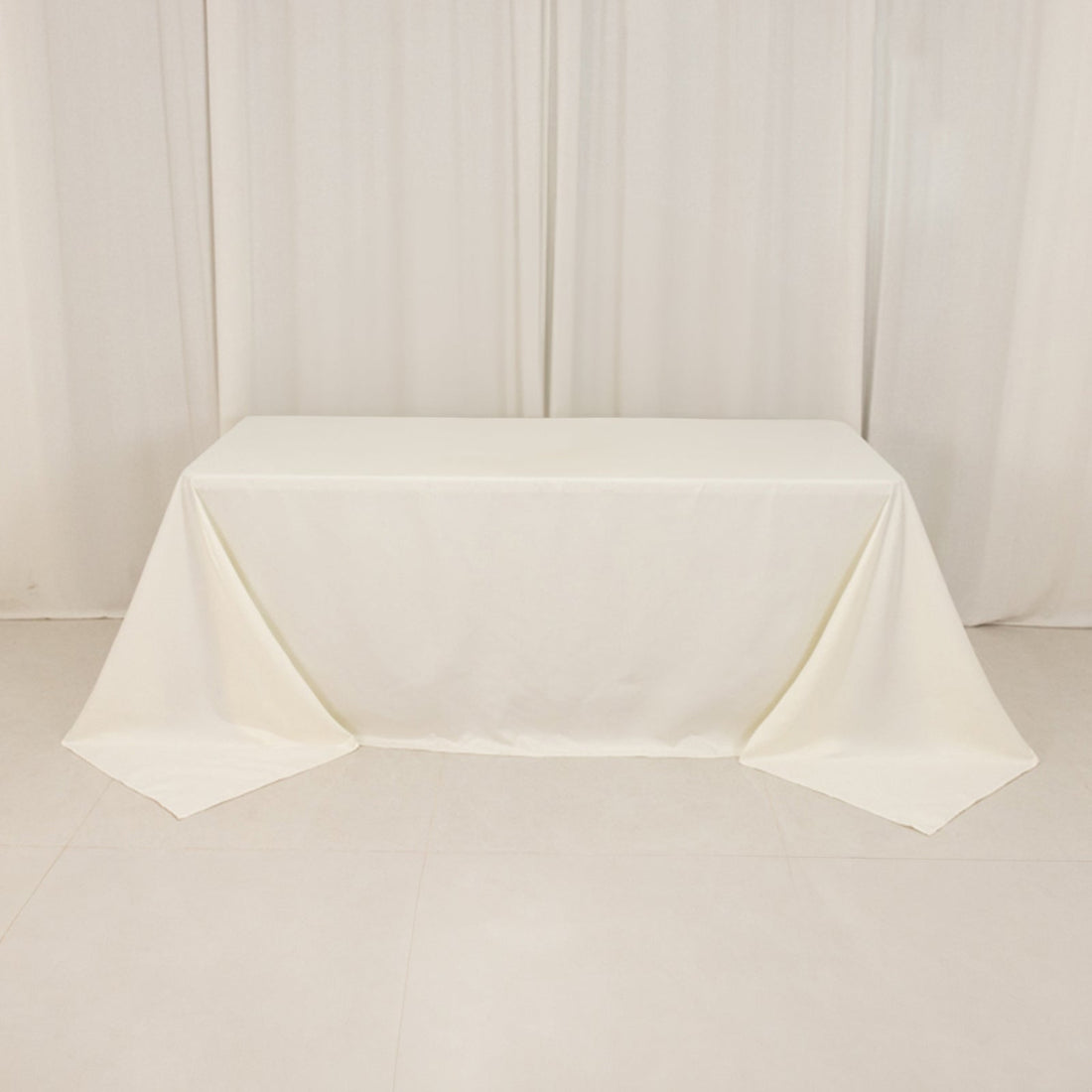 Plain white tablecloth draped over a table in a minimalistic setting.
