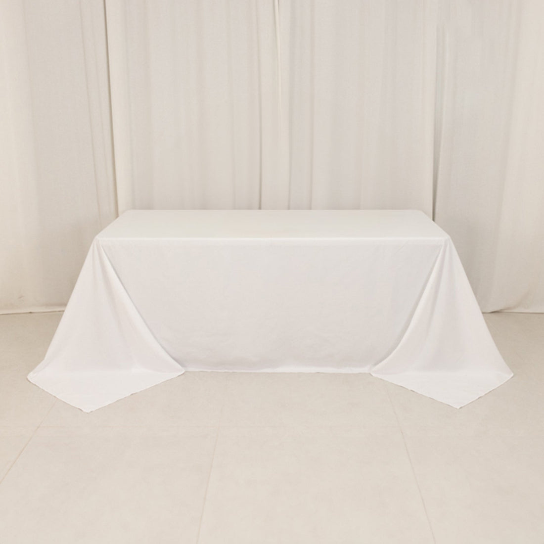 White tablecloth draped over a table in a studio setting.
