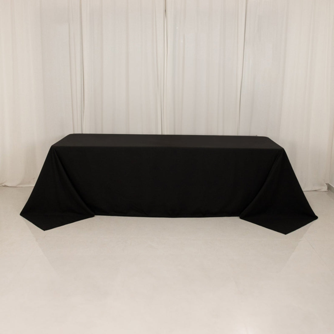 Black tablecloth draped over a table in a studio setting.