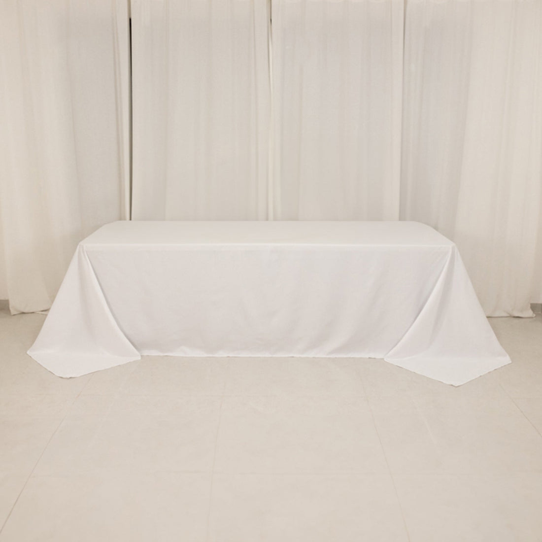 White tablecloth draped over table in a studio setting.