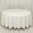 Round white table with a draped tablecloth.