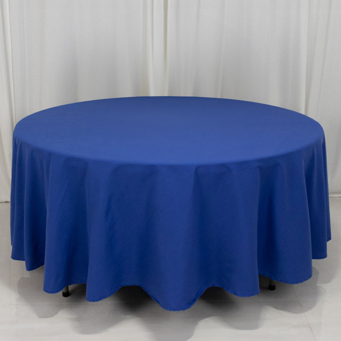 Round blue tablecloth draped over a circular table.