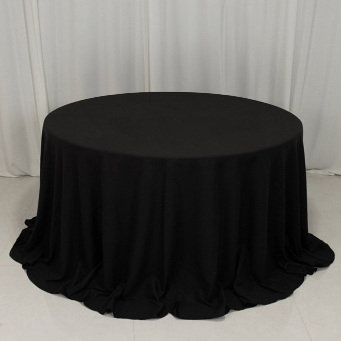 Round black tablecloth draping elegantly over a table.