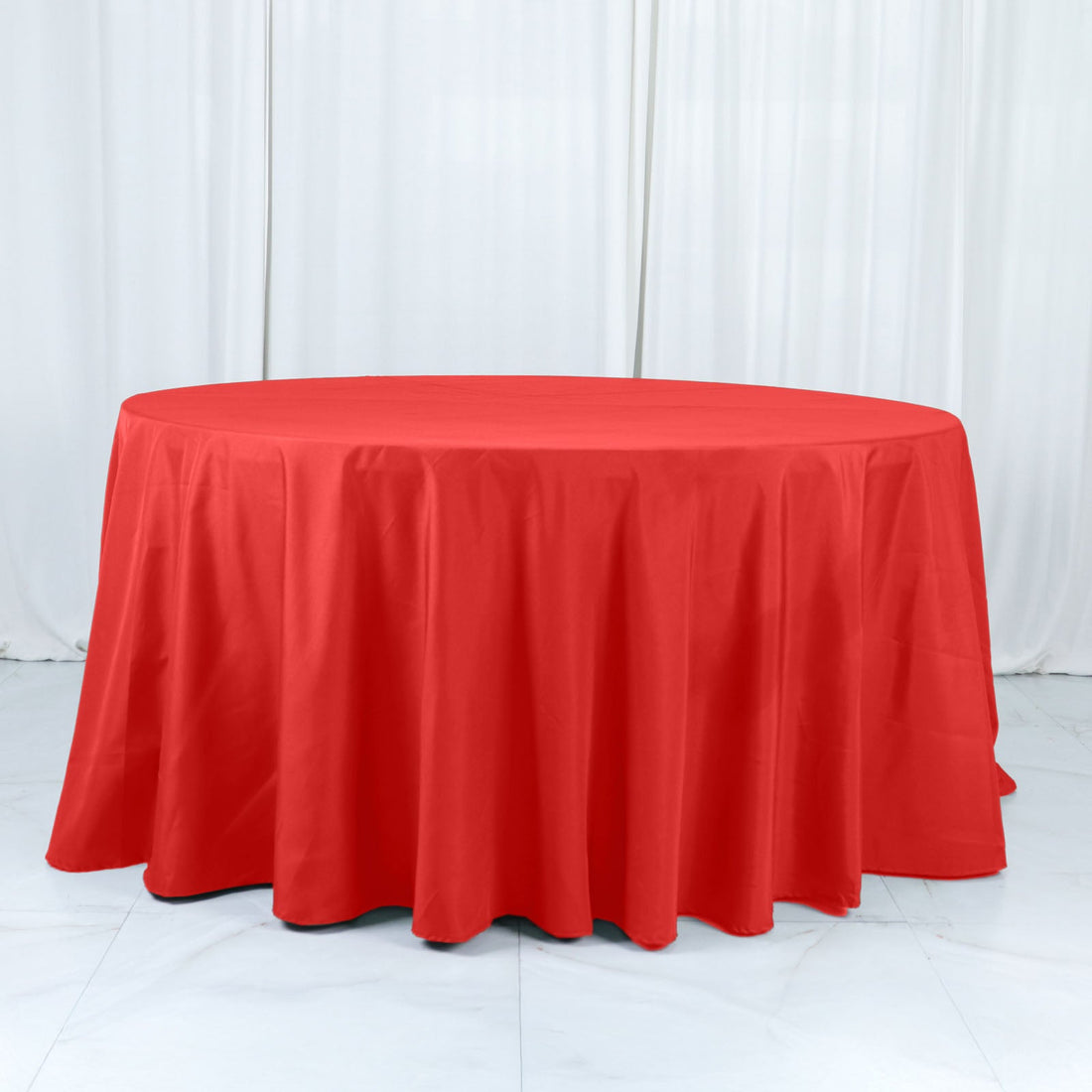 Red round tablecloth on a white surface.