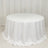 Round white table with a draped tablecloth in a studio setting.