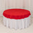 Red round tablecloth draped over a white table.
