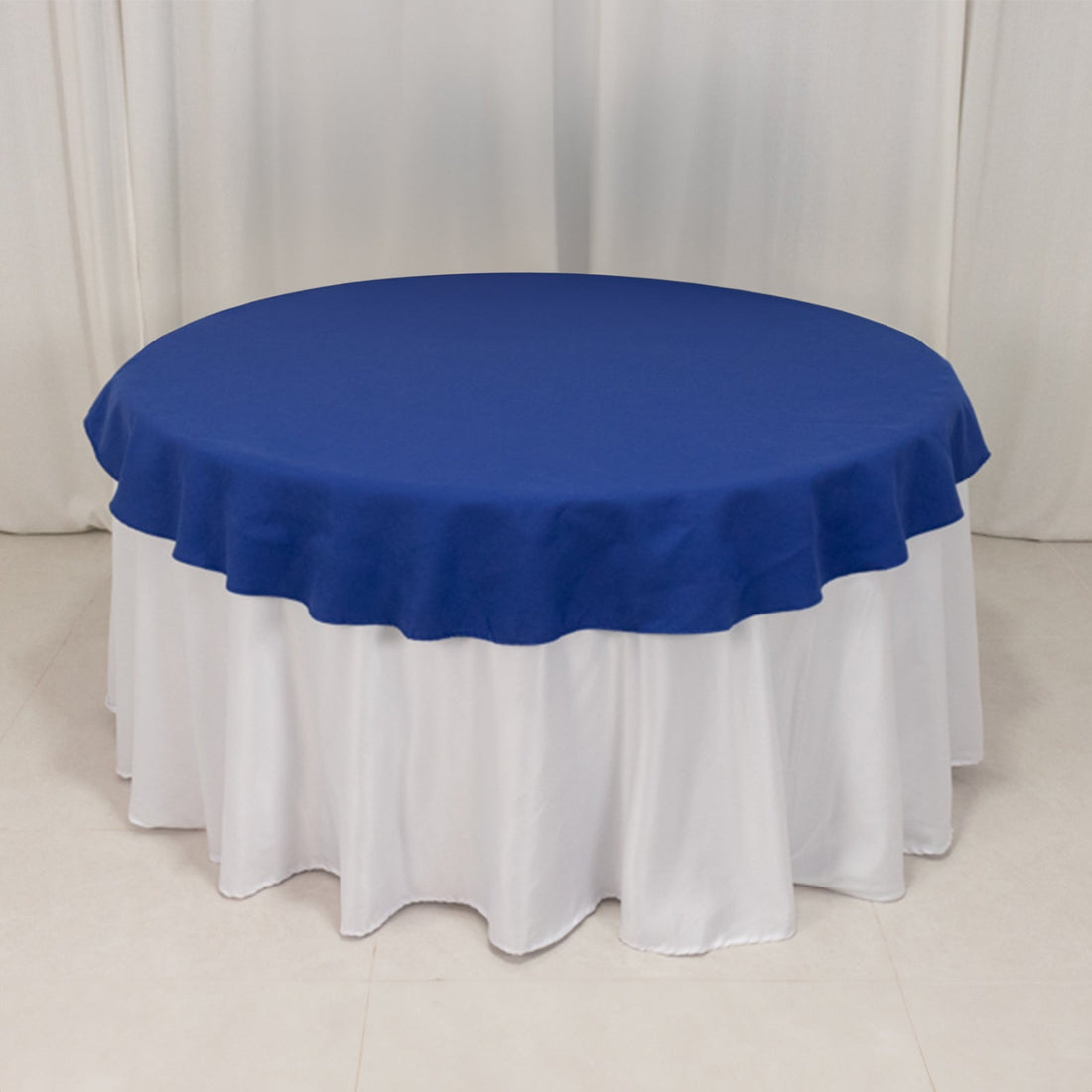 Round blue tablecloth draped over a white table