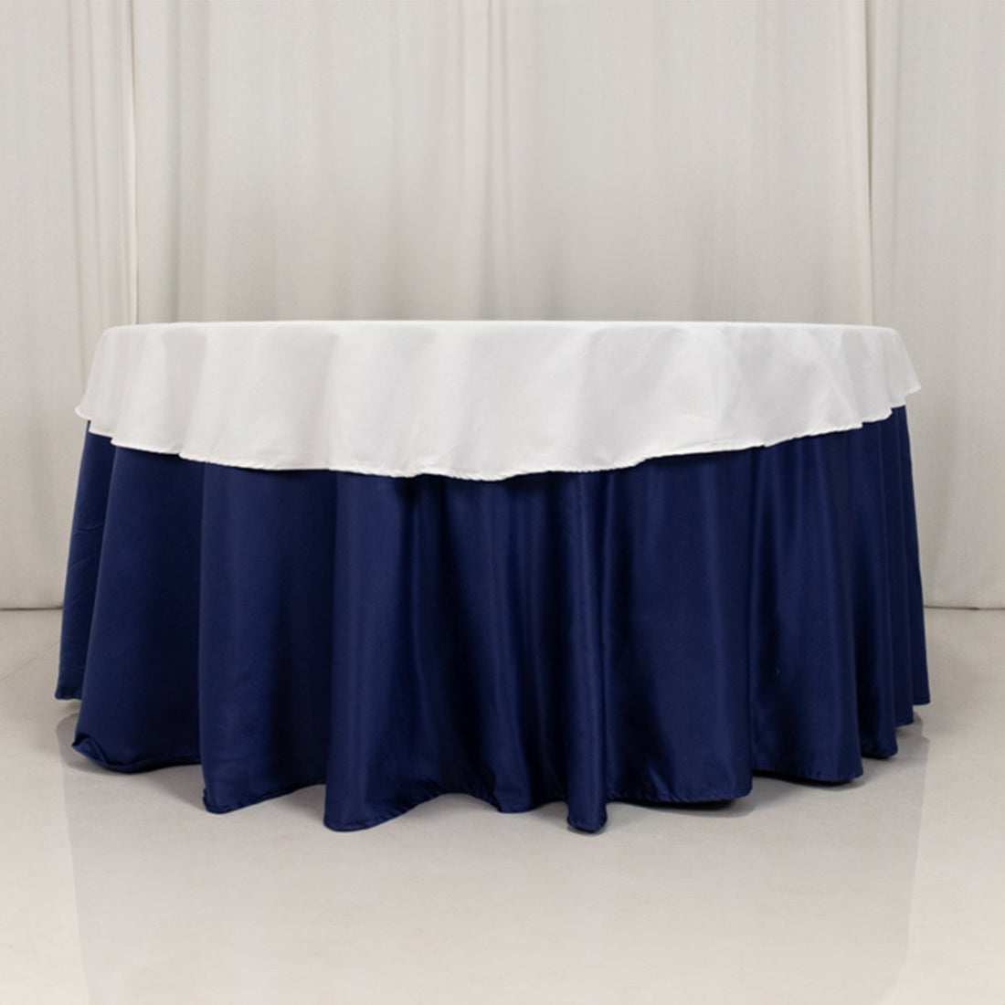 Round table with navy blue skirt and white tablecloth