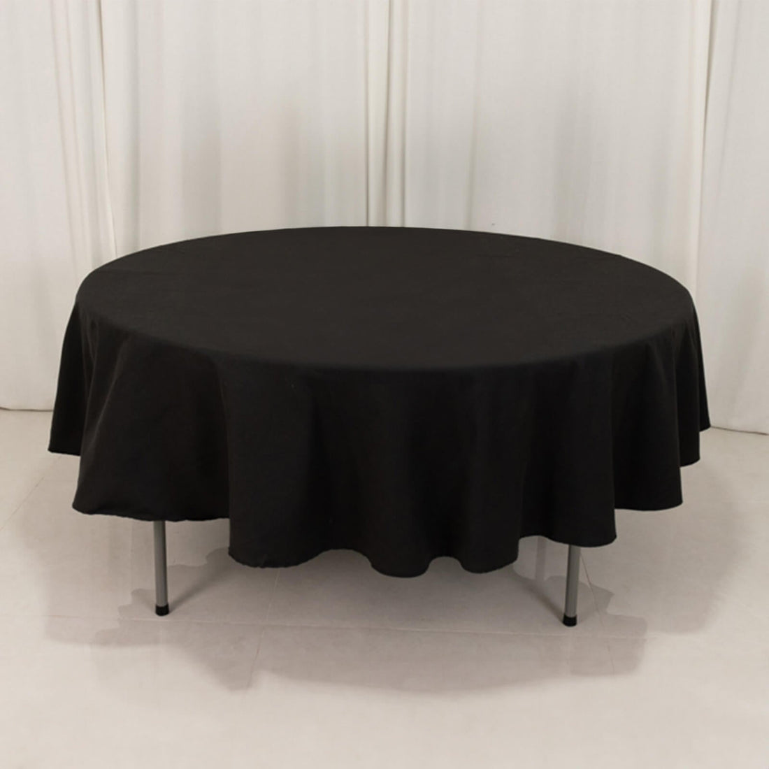 Round black tablecloth draped over a circular table.
