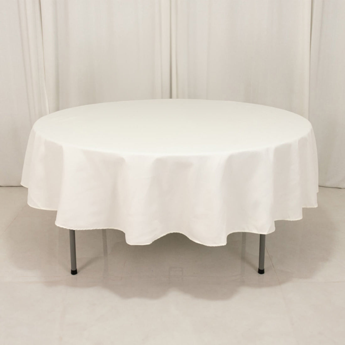Round white table with a draped tablecloth