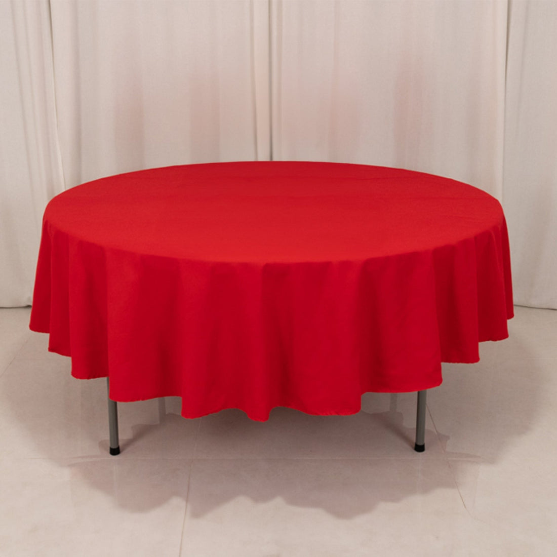 Red round tablecloth draped on a table, showcasing vibrant color and fabric texture.