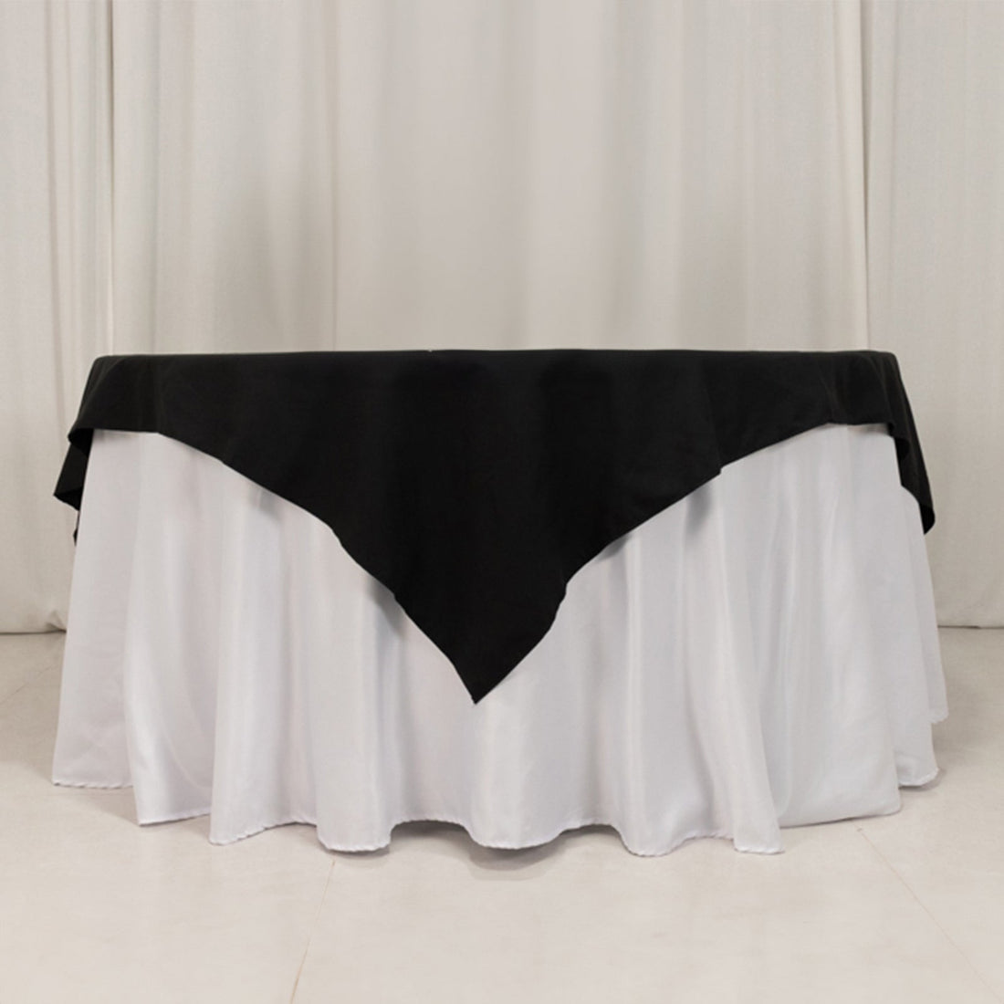 Black and white tablecloth on a round table in a studio setting