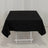 Black tablecloth draped over a white folding table