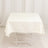 White tablecloth draped over a folding table in a studio setting.