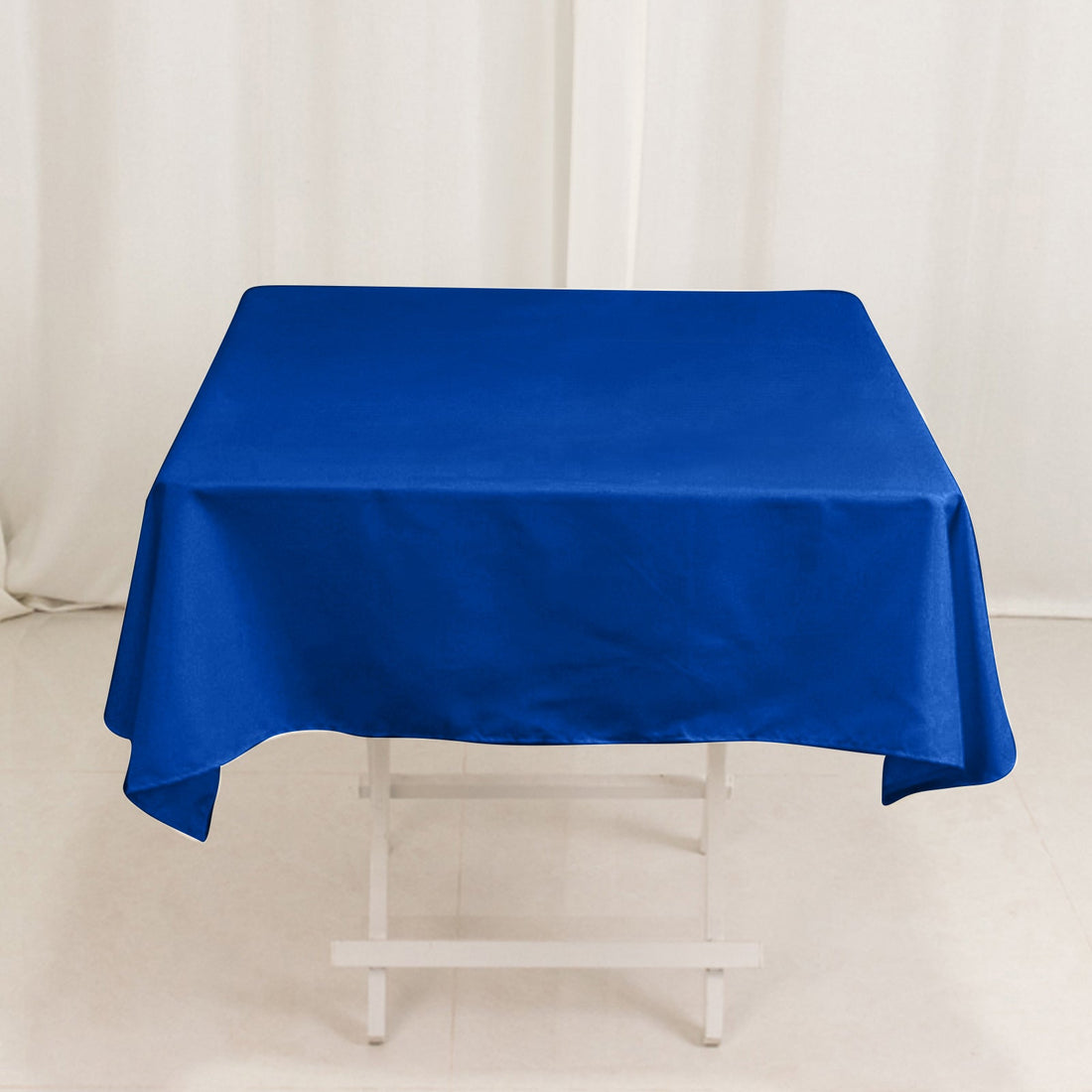 Blue tablecloth on a white table against a plain backdrop.