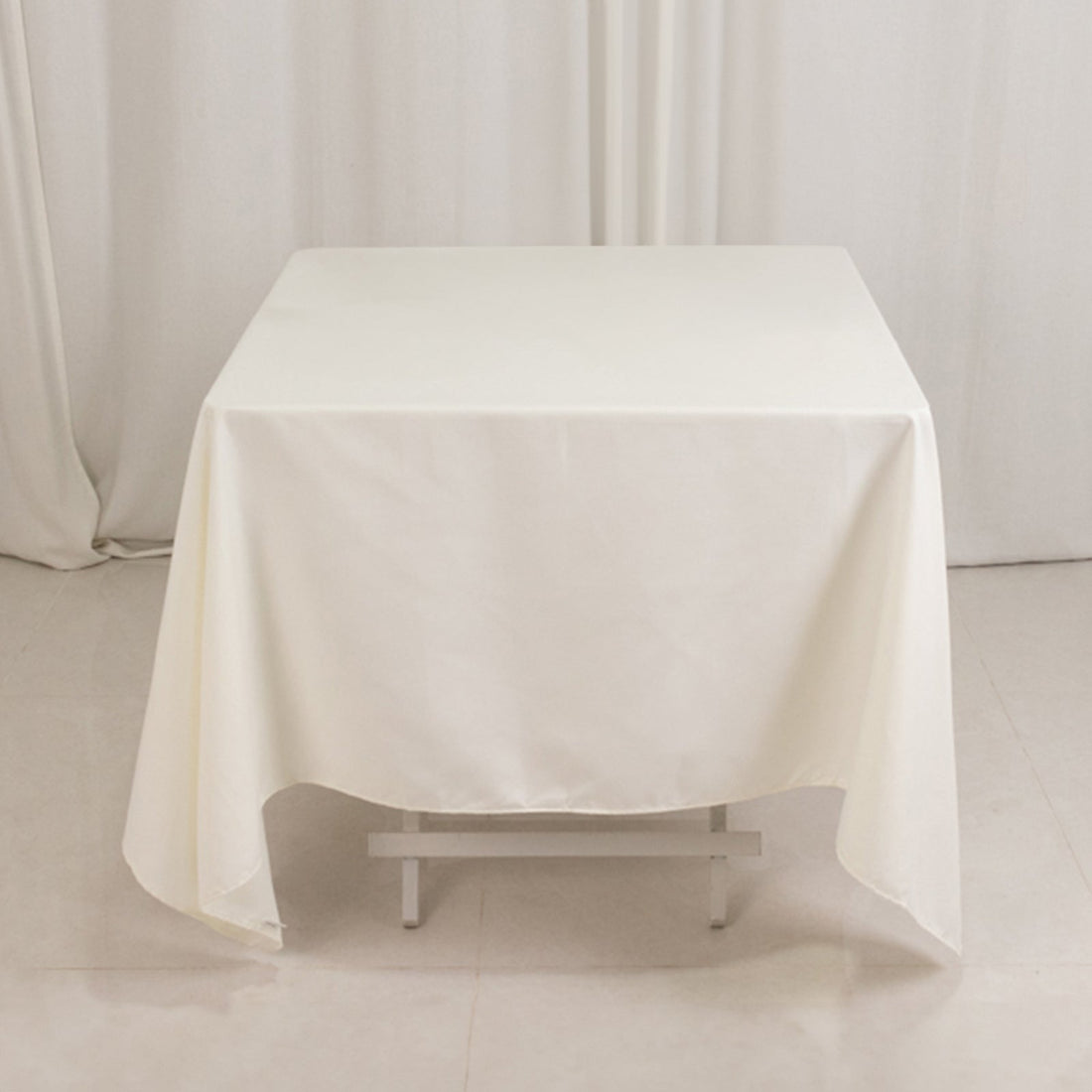White tablecloth draped over a table in a studio setting.