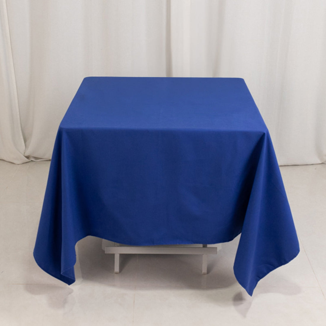 Blue tablecloth draped on a table in a studio setting.