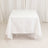 White tablecloth draped over a square table in a studio setting.