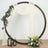 Decorative circular backdrop with flowers, drapes, and lanterns for events or photoshoots.