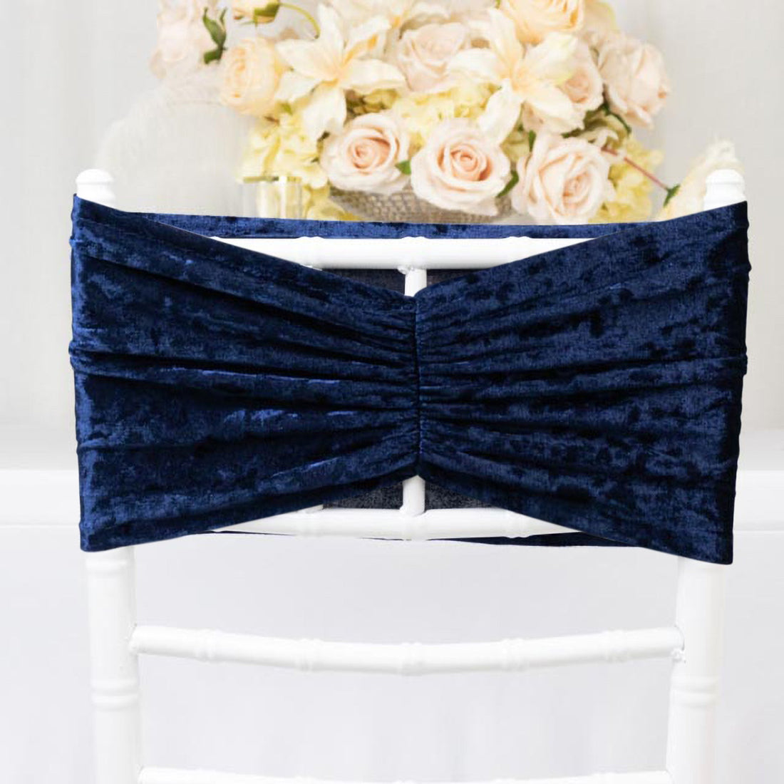 Navy velvet chair sash with pleated design on a white chair.