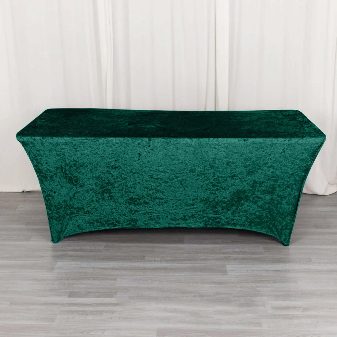 Green velvet table cover on a plain backdrop.