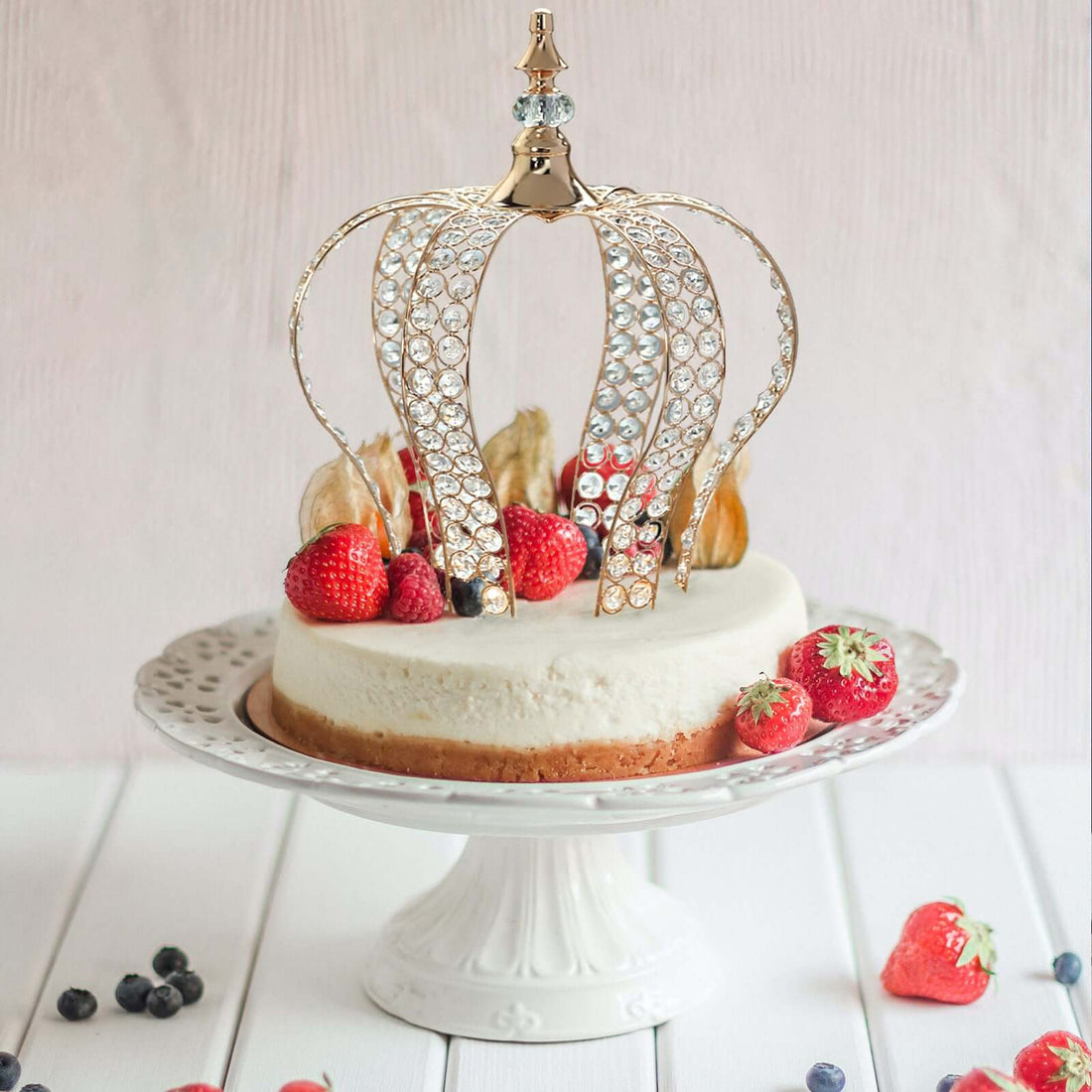 Elegant cake topped with a sparkling crown and fresh berries.