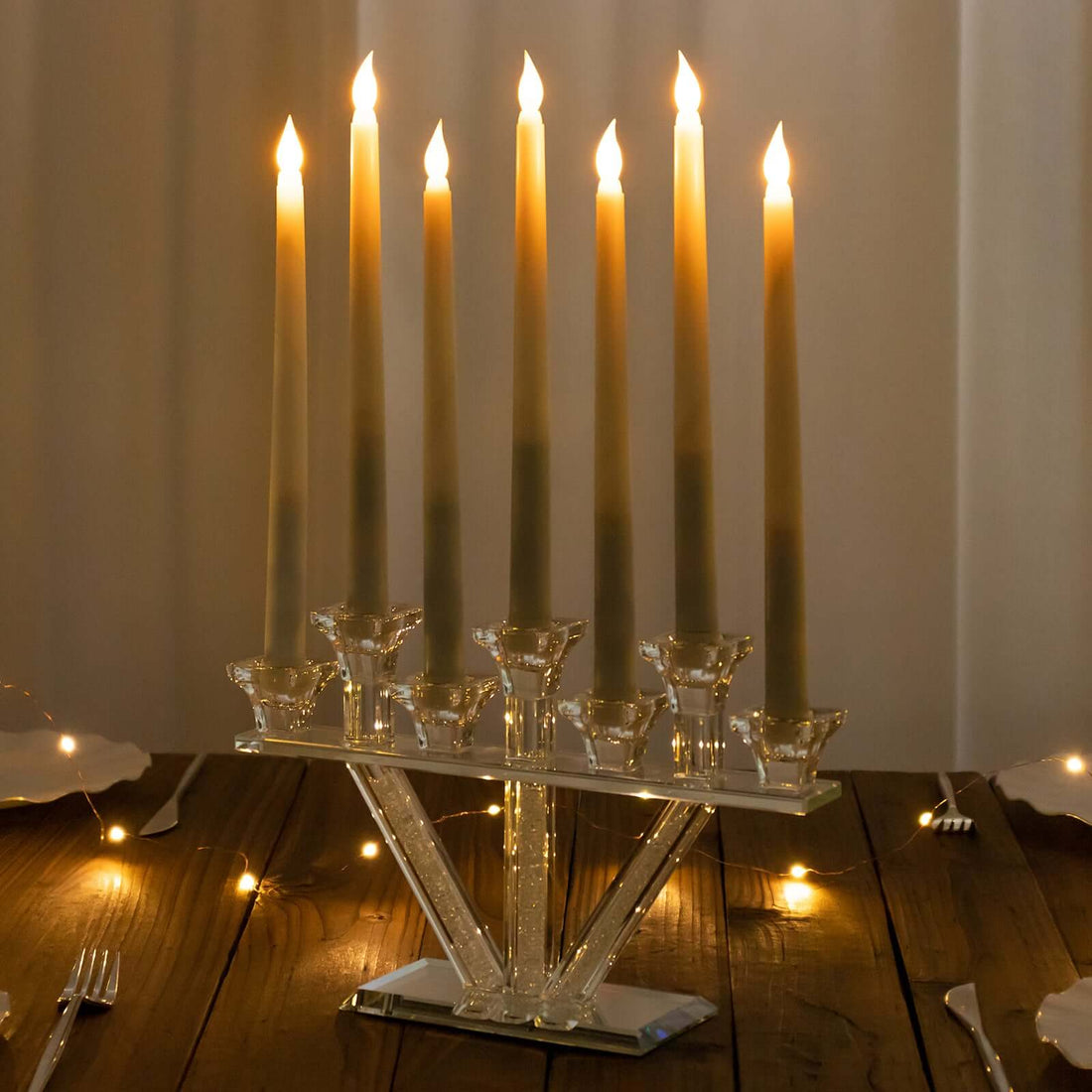 Elegant crystal candle holder with six lit candles on a wooden table.