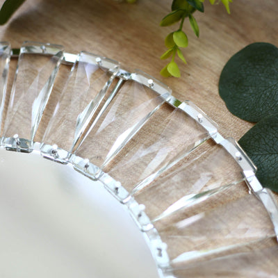 Crystal glass serving tray with geometric design on a wooden table with greenery