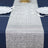 Sparkling silver table runner on a navy blue tablecloth.