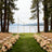 Elegant wedding ceremony setup by a lake with floral arrangements and chairs.