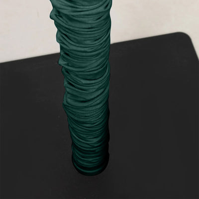 Dark green textured grip handle on black surface, close-up view