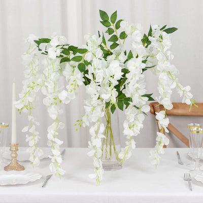 Artificial white orchid arrangement in a clear vase for elegant decor.