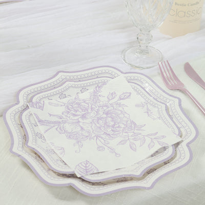 Elegant floral paper plates and napkin set on a textured tablecloth.