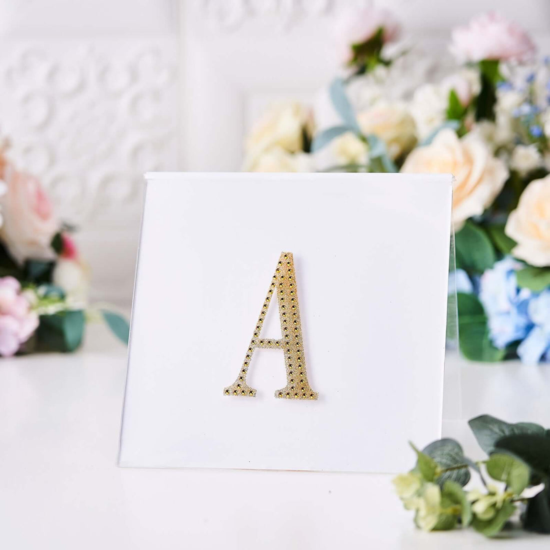 Gold letter "A" decorative sign on a white background.