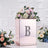 Mirrored floral arrangement box with diamond letter 'B' and pink flowers.