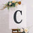 Decorative letter "C" on an easel with flowers, ideal for events or celebrations.