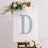 Decorative letter "D" adorned with flowers on an easel.