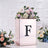 Floral arrangement in a decorative box with letter "F" on a textured background.
