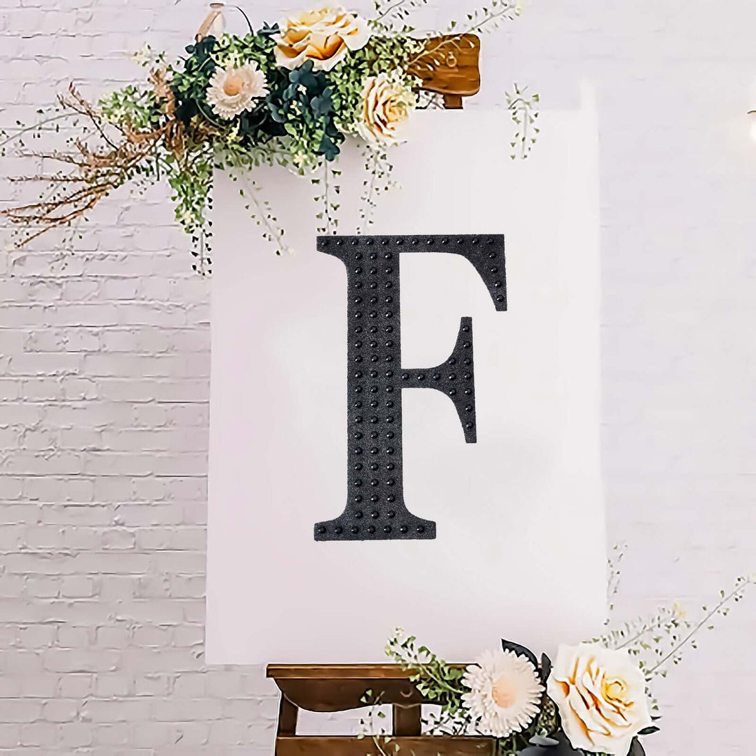 Decorative letter "F" on a floral backdrop.