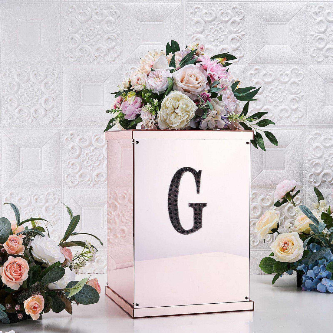 Elegant floral arrangement in a rose gold box with a "G" monogram.