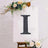 Decorative letter "I" displayed on an easel with flowers