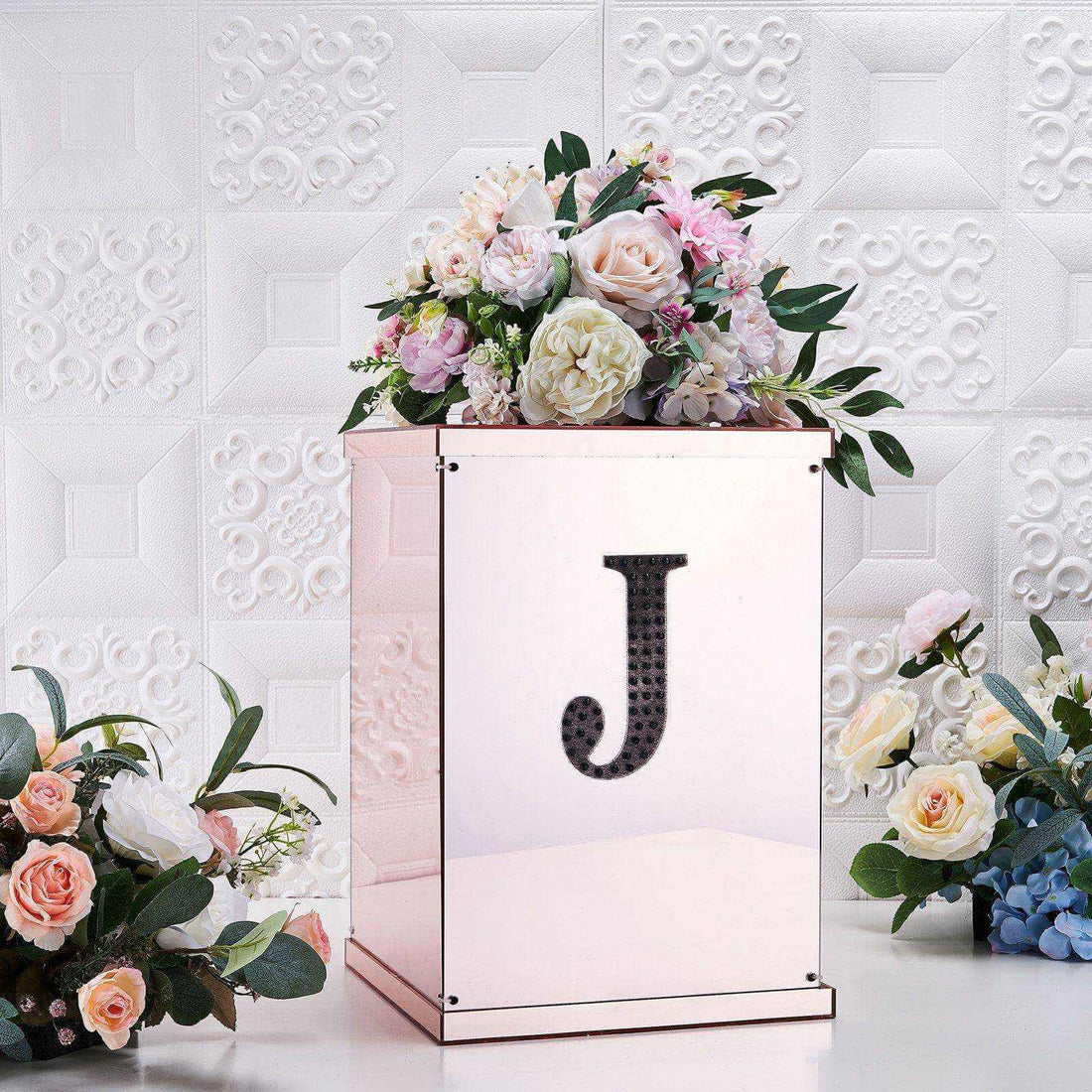 Elegant rose gold floral arrangement box with initial "J" and decorative flowers.