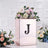 Elegant rose gold floral arrangement box with initial "J" and decorative flowers.